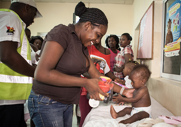 Angolan mother and baby playing with toys at clinic