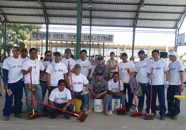 Group photo of team cleaning up school in Ecuador