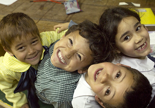 A group of school kids grinning for the camera